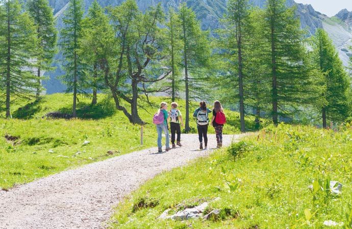 Enfants sur un chemin de randonnée avec leur sac-à-dos