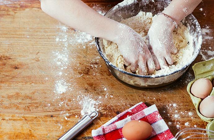 enfant qui pétri une pâte en atelier art culinaire ludique