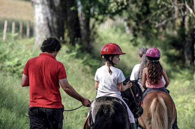 Enfants en promenade à dos de poneys