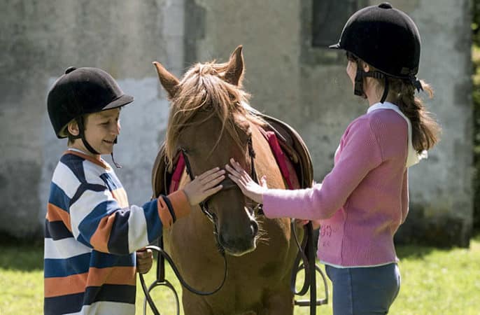 Enfants qui caressent un poney