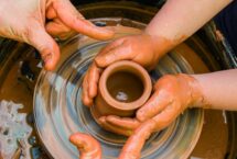 Mains d'enfant et d'adulte tournage poterie