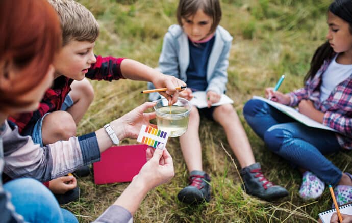 enfants en atelier découverte de l'eau en classe sans cartable