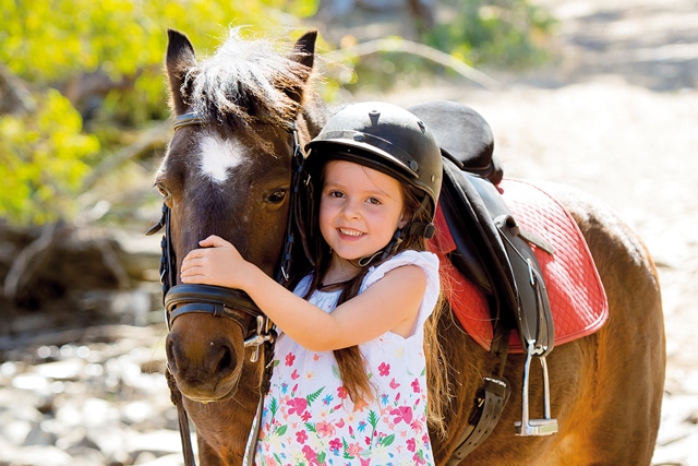 Fillette qui promène un poney