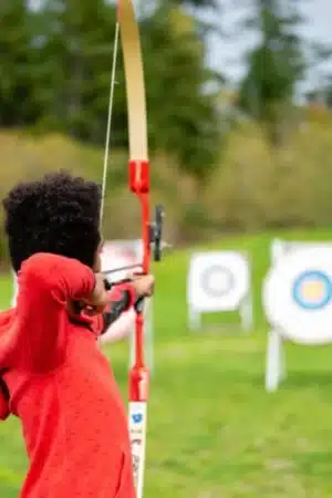 élève au tir à l'arc avec cible à l'extérieur