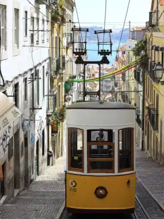 Tramway jaune de lisbonne dans la ville avec mer en arrière plan