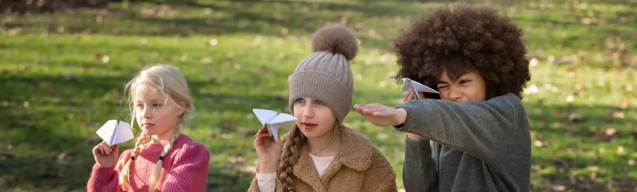 eleves jouant avec avion en papier dehors