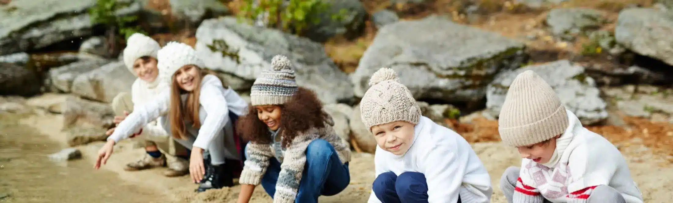 élèves en classe découverte mains dans rivière
